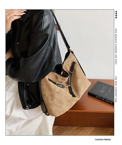 Bolso tote de ante marrón con correas de cuero negro y hebilla de metal en modelo