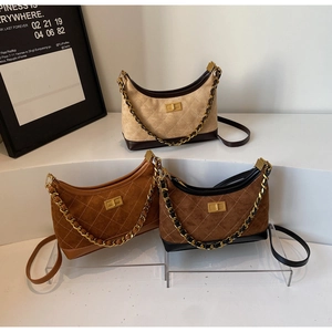 Detailed view of suede crescent bags in beige and brown with quilted textures and gold hardware