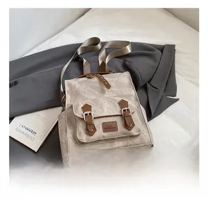 Close-up of vintage backpack details with brown faux leather straps and metal buckles