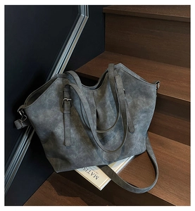 Detail of dark gray tote bag showing matte texture and adjustable buckle straps