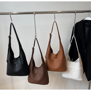 Détail des sacs seau en cuir tressé en quatre couleurs avec bretelles réglables