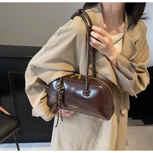 Detail of a vintage dark brown bowling bag with glossy leather and zipper closure
