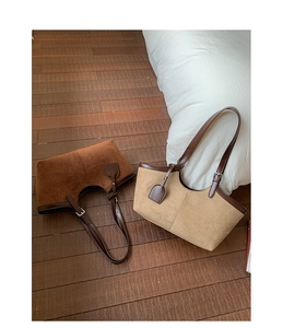 Detail of suede tote bag in brown and beige with leather trim and adjustable straps