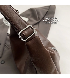 Detailed close-up of adjustable silver buckle and premium brown leather texture on tote bag