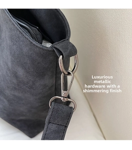 Detail of premium silver-tone metal hardware and stitching on a dark gray tote bag
