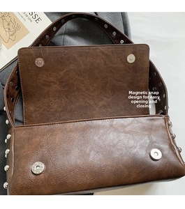 Détail d'un sac vintage en cuir marron avec rivets argentés et fermoir magnétique