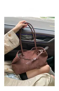 Dettaglio della borsa tote in pelle opaca marrone scuro con fibbia argentata e scamosciata
