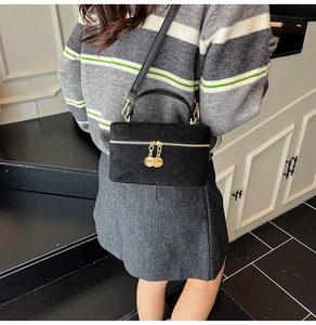 Close-up of black quilted bucket bag with matte texture and elegant gold hardware