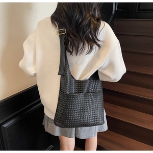Détail du sac hobo en cuir tressé noir avec bandoulière réglable et ferrures dorées
