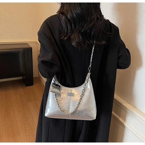 Detail of silver pleated shoulder bag with metallic chain and small coin purse pendant