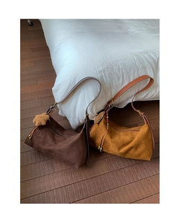 Detail view of suede hobo bags in coffee and caramel with stylish star charm and beads