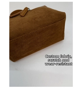 Détail du sac à main en daim marron montrant les coutures durables et la texture du tissu