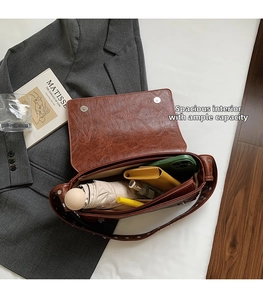 Intérieur spacieux du sac à bandoulière marron plissé avec divers articles essentiels