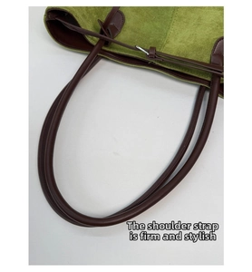 Dettaglio della cucitura rinforzata della tracolla su una borsa tote in pelle scamosciata