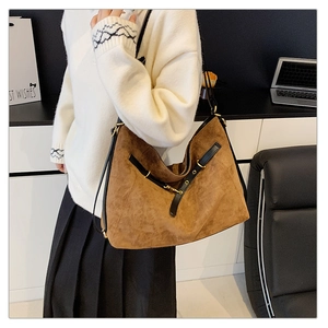 Vista detallada del bolso tote marrón caramelo con detalles de correas de cuero negro