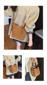 Detail view of brown matte bucket bag with adjustable strap and decorative side knot