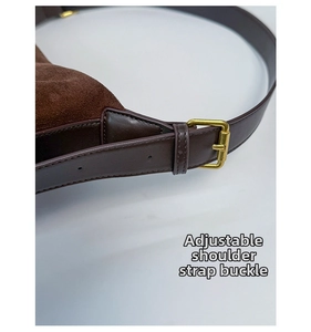 Detail of adjustable shoulder strap with vintage gold buckle on brown leather bag