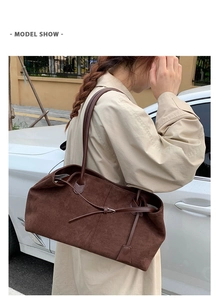 Vista dettagliata della borsa tote in pelle scamosciata marrone scuro con ciondolo decorativo