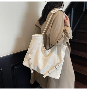 Vue détaillée du grand sac cabas en cuir PU crème avec boucles métalliques sur un modèle