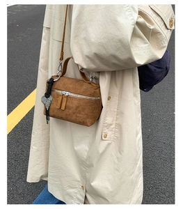 Vue détaillée d'un mini sac carré en daim marron avec pendentif en cœur et corde tressée