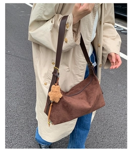 Close-up of brown suede hobo bag featuring leather strap and plush star pendant detail