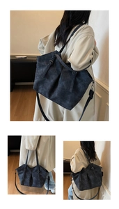 Detail of vintage charcoal tote bag with buckled straps and adjustable shoulder strap