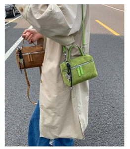Gros plan de sacs à bandoulière en daim vert et marron avec pendentifs cœur et tissés