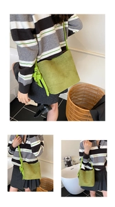 Detail of green suede bucket bag featuring side drawstring ribbons and long strap
