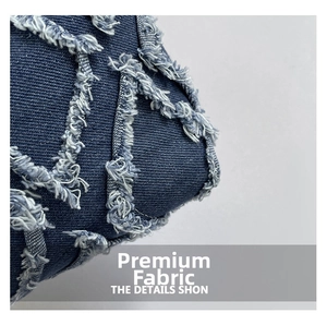 Dettaglio del tessuto denim blu scuro con trama a rombi e frange per borse