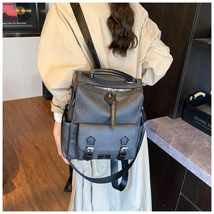 Detail of vintage textured backpack with silver zippers and buckle straps on wide nylon straps