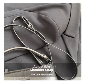 Detail van verstelbare schouderriem op de minimalistische donkerlederen crossbodytas