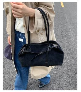 Dettaglio di una borsa tote in pelle nera spazzolata minimalista con spalline sottili