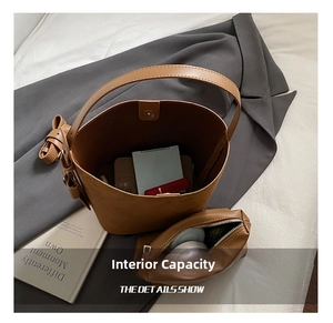 Interior view of brown bucket bag showing capacity for phone and cosmetics