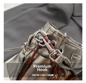Detail van de zilveren metallic leren tas met gepolijste metalen haak en modelabel