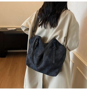 Detailed view of grey frosted tote bag texture with adjustable strap and shoulder handles