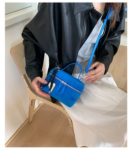 Détail du mini sac carré en daim bleu roi avec double zip et pendentif en forme de cœur