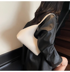 Detail of hobo shoulder bag showing off-white lychee pattern leather and seamless hobo design