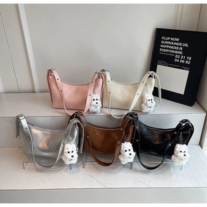 Detailed view of half-moon hobo bags in five colors with plush puppy charms