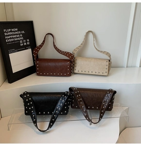Détail de quatre sacs à bandoulière à rivets rétro en plusieurs couleurs sur présentoir