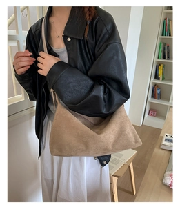 Khaki suede baguette bag styled with a black leather jacket and long white skirt