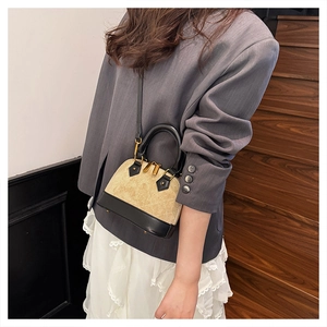 Détail d'un sac à main beige matelassé avec finitions en cuir noir et zip doré