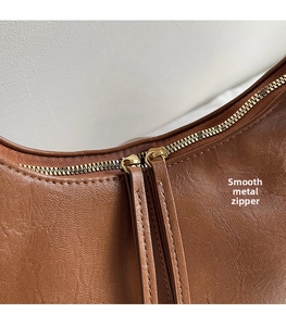 Détail rapproché des fermetures éclair métalliques et texture du cuir de ce sac
