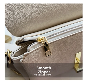 Macro detail of high-quality smooth golden zipper on beige lychee pattern crossbody bag