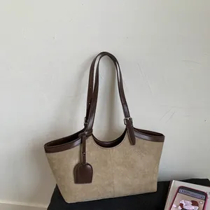 Detail of vintage suede tote bag showing contrast leather trim and adjustable strap buckle