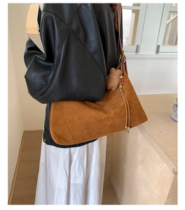 Brown suede baguette bag detail with cute bear plush charm and beaded tassel accents