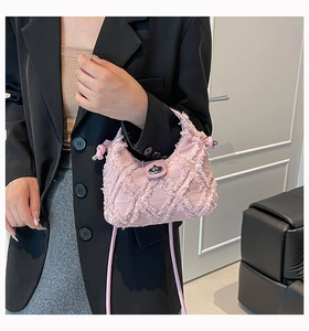 Dettaglio borsa a tracolla in denim rosa con motivo a rombi sfrangiati e chiusura girevole argento