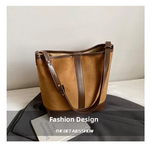 Detail showing the retro brown suede bucket bag with smooth leather trim and adjustable strap
