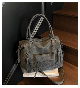 Dettaglio borsa tote vintage grigio scuro con cerniere su scale di legno
