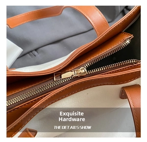 Détail du sac cabas bicolore avec fermeture éclair en métal doré et garniture en cuir