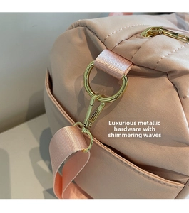 Detail of pink sports bag showing gold D-ring and lobster clasp hardware and nylon fabric